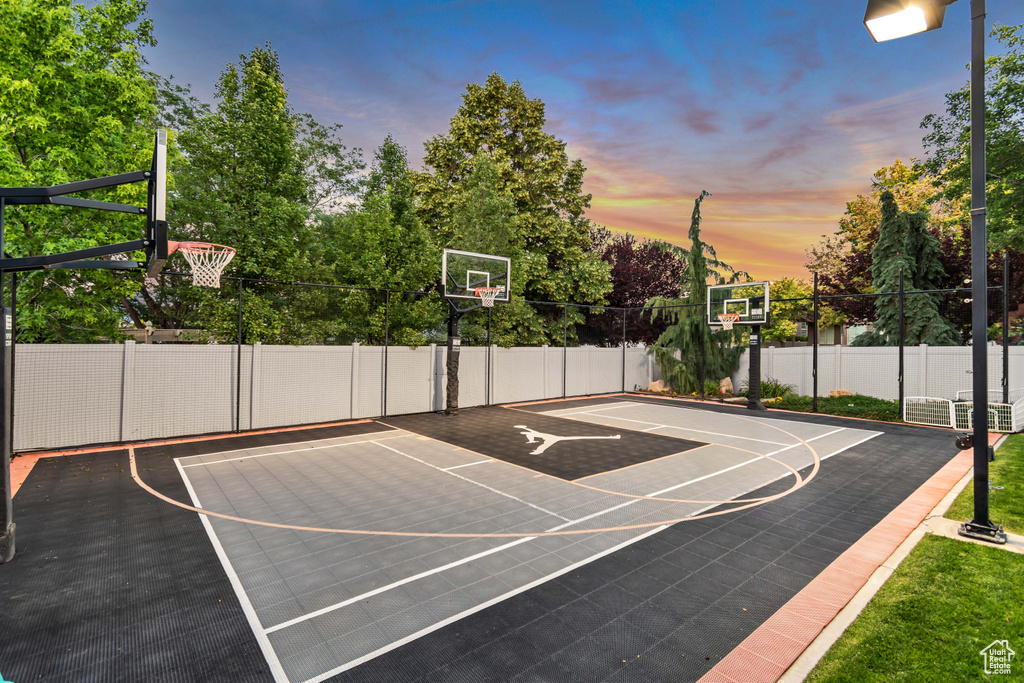 View of sport court featuring basketball court and view of scattered trees