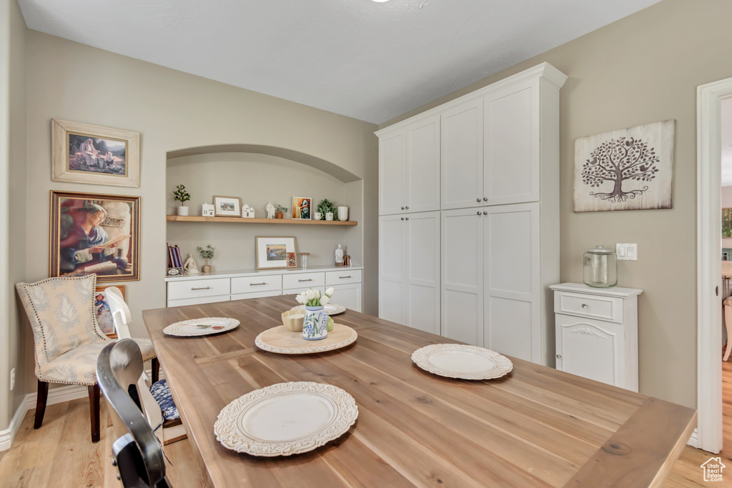 Dining room with light wood-style floors and built in features