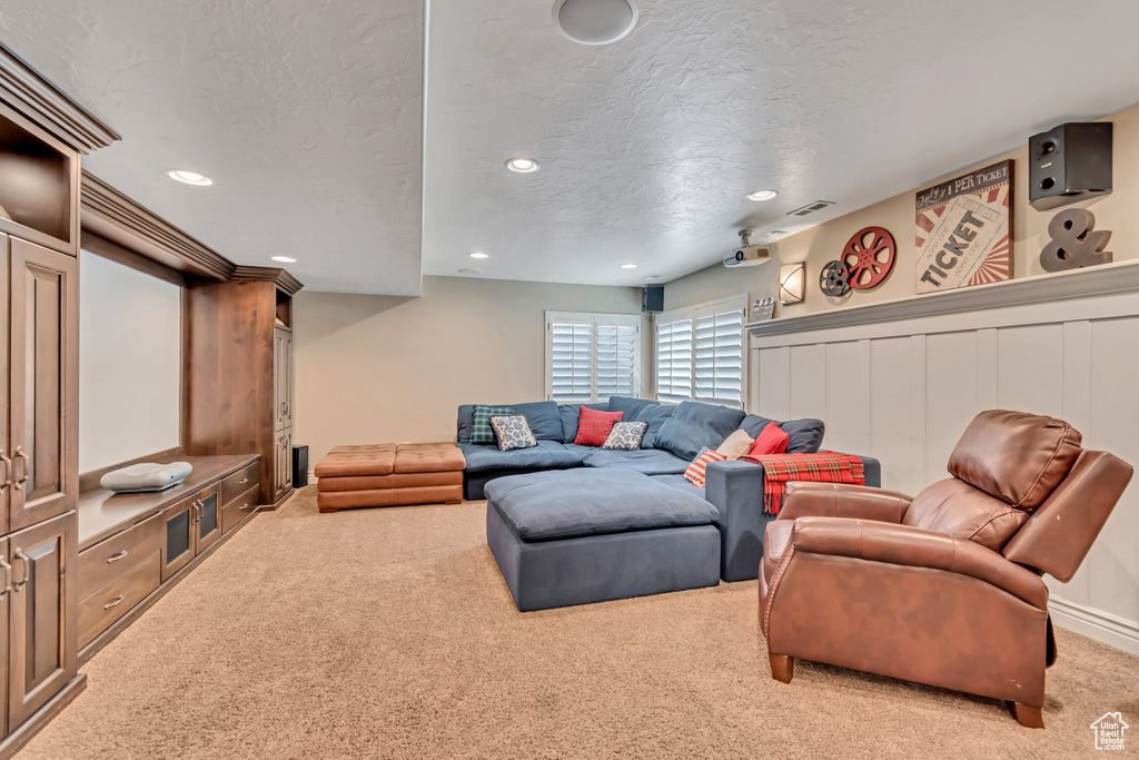 Living area with carpet floors, a textured ceiling, and recessed lighting