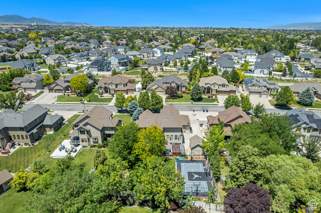 Aerial view of property and surrounding area featuring nearby suburban area and a mountain backdrop