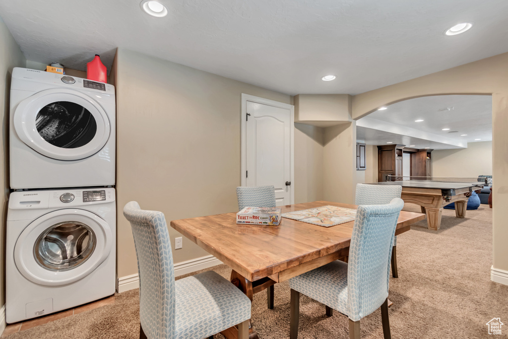 Dining room with stacked washer / drying machine, recessed lighting, light carpet, and arched walkways