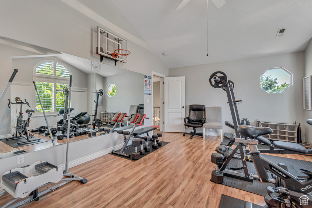 Exercise room featuring vaulted ceiling, wood finished floors, and ceiling fan