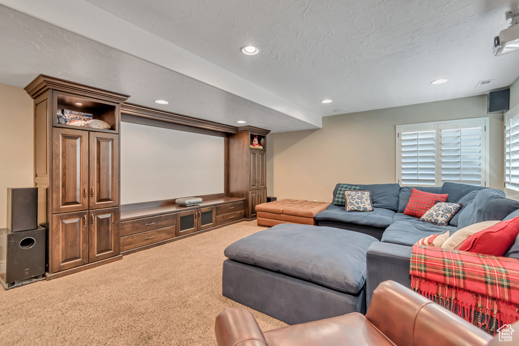 Carpeted home theater room with recessed lighting and a textured ceiling