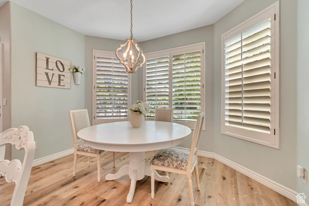 Dining space with hardwood / wood-style floors, a chandelier, and plenty of natural light