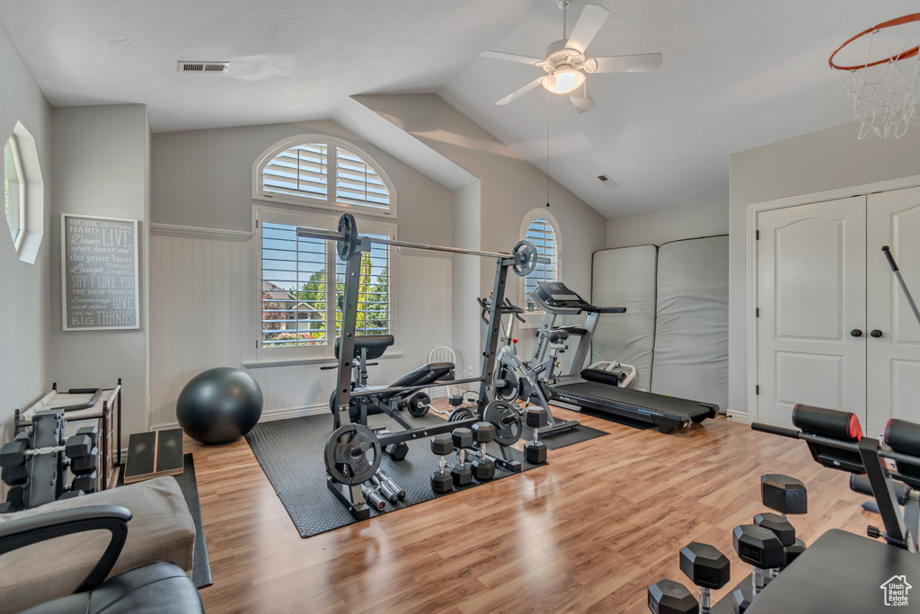 Workout room featuring wood finished floors, a ceiling fan, and vaulted ceiling