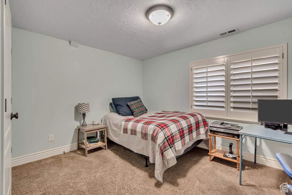 Bedroom featuring a textured ceiling and carpet flooring