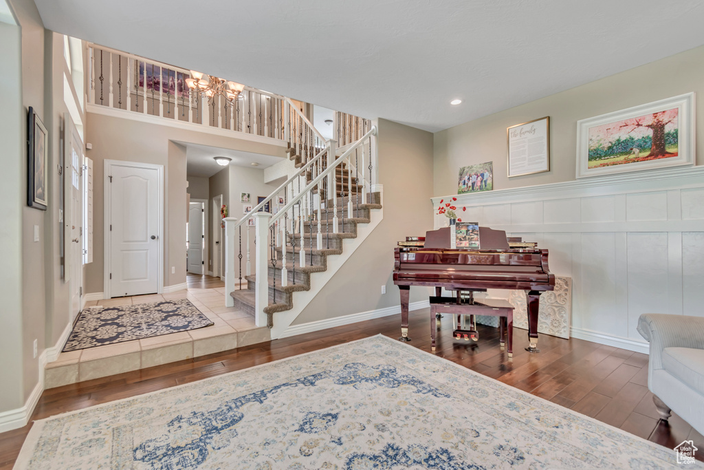 Foyer featuring wood finished floors, a chandelier, stairway, and recessed lighting