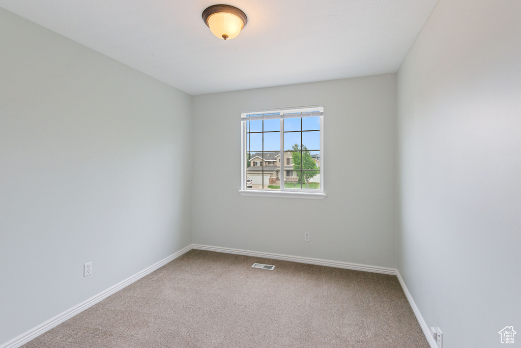 Carpeted empty room with baseboards
