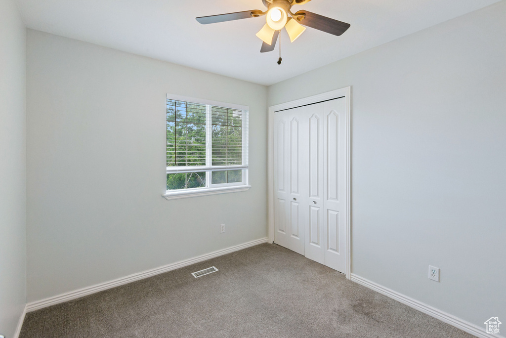 Unfurnished bedroom with carpet floors, a closet, and ceiling fan