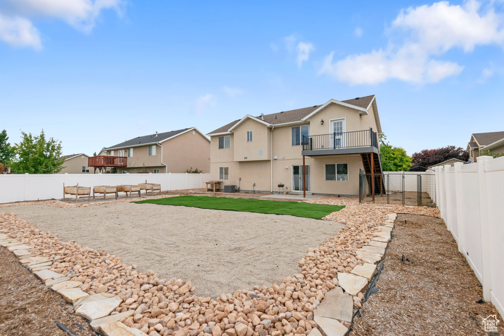 Rear view of house featuring stucco siding, a residential view, a fenced backyard, a patio, and a balcony
