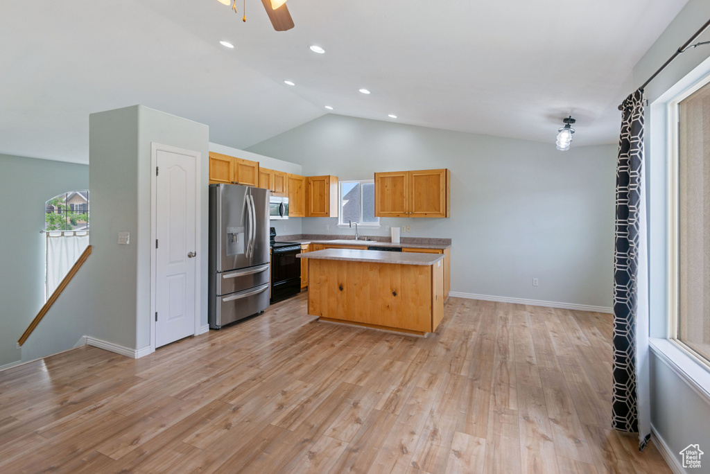Kitchen featuring appliances with stainless steel finishes, light countertops, a center island, light wood-style floors, and recessed lighting