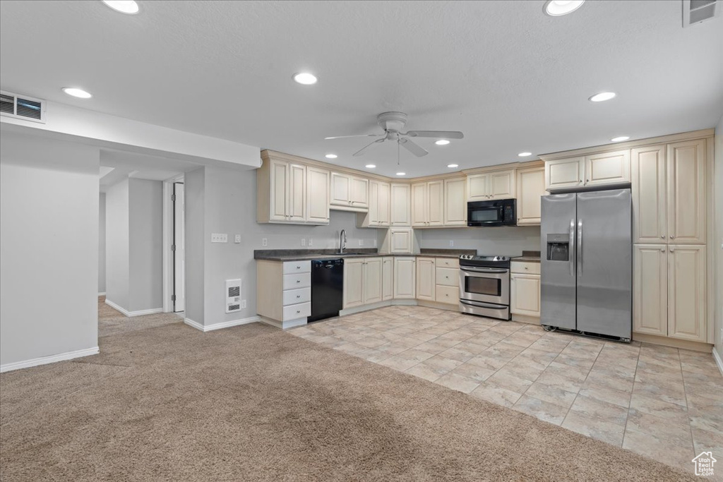 Kitchen featuring black appliances, cream cabinets, a ceiling fan, light carpet, and recessed lighting