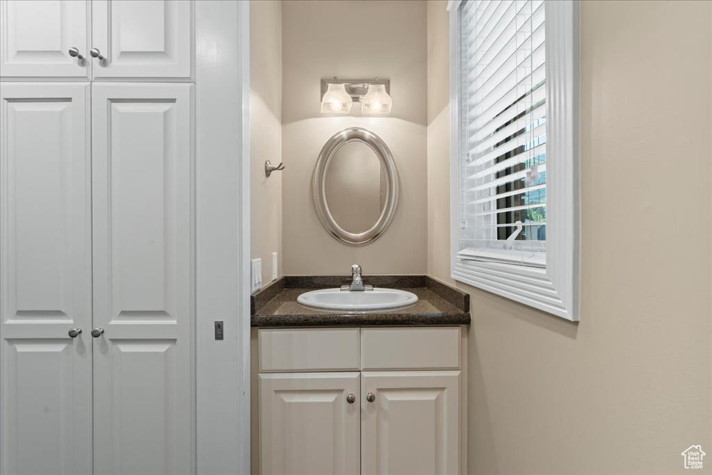Bathroom with vanity and a closet