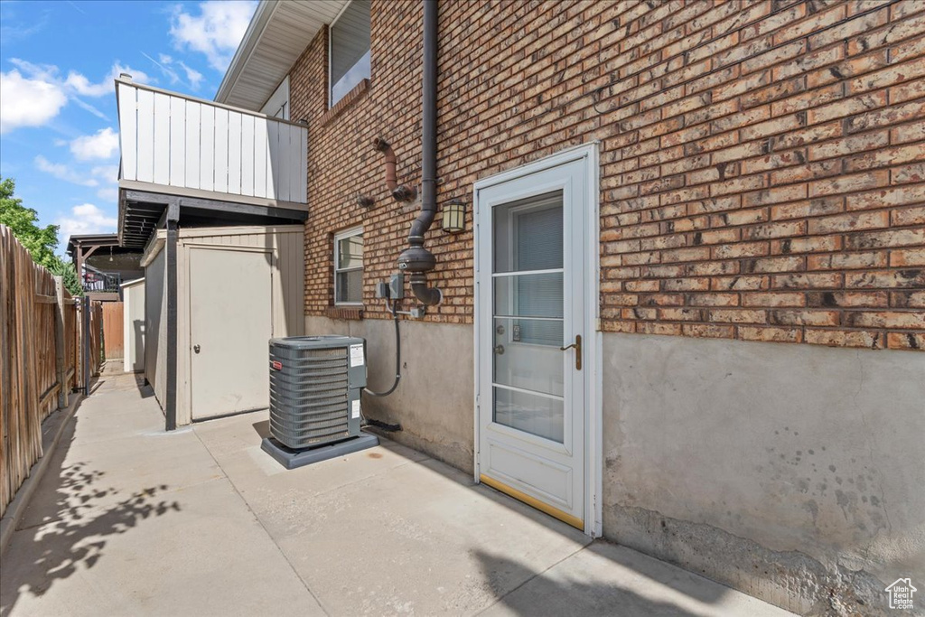 Property entrance featuring brick siding and a patio area