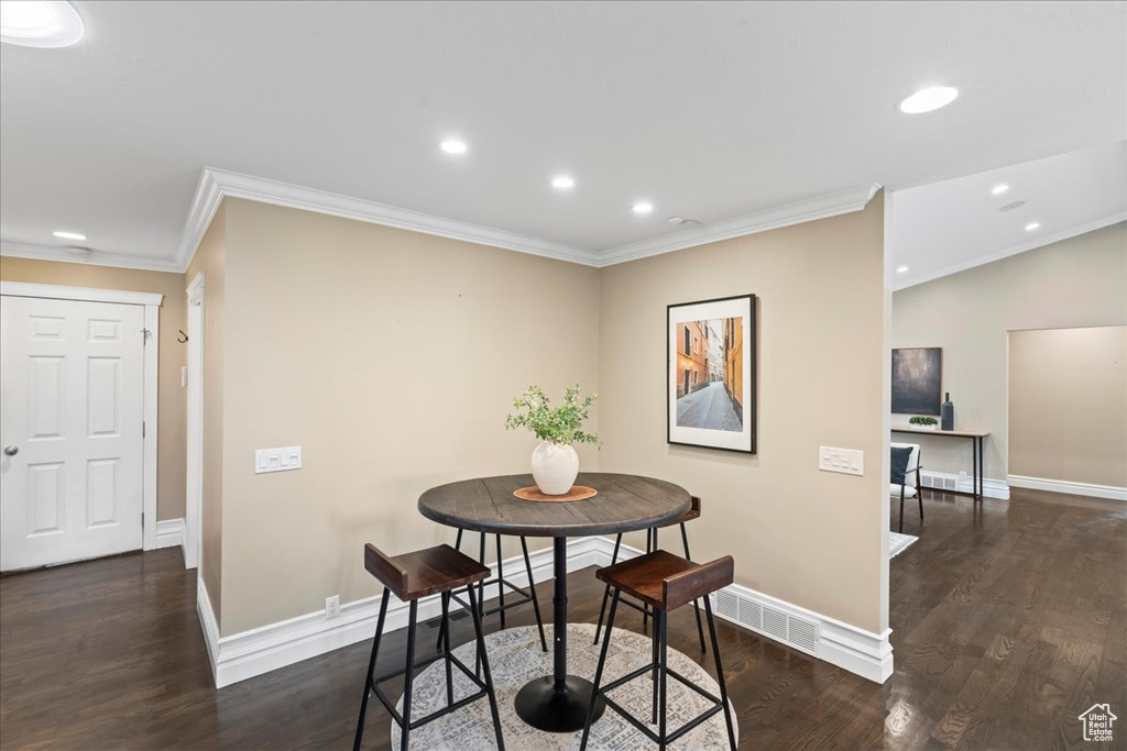 Dining space featuring crown molding, wood finished floors, and recessed lighting