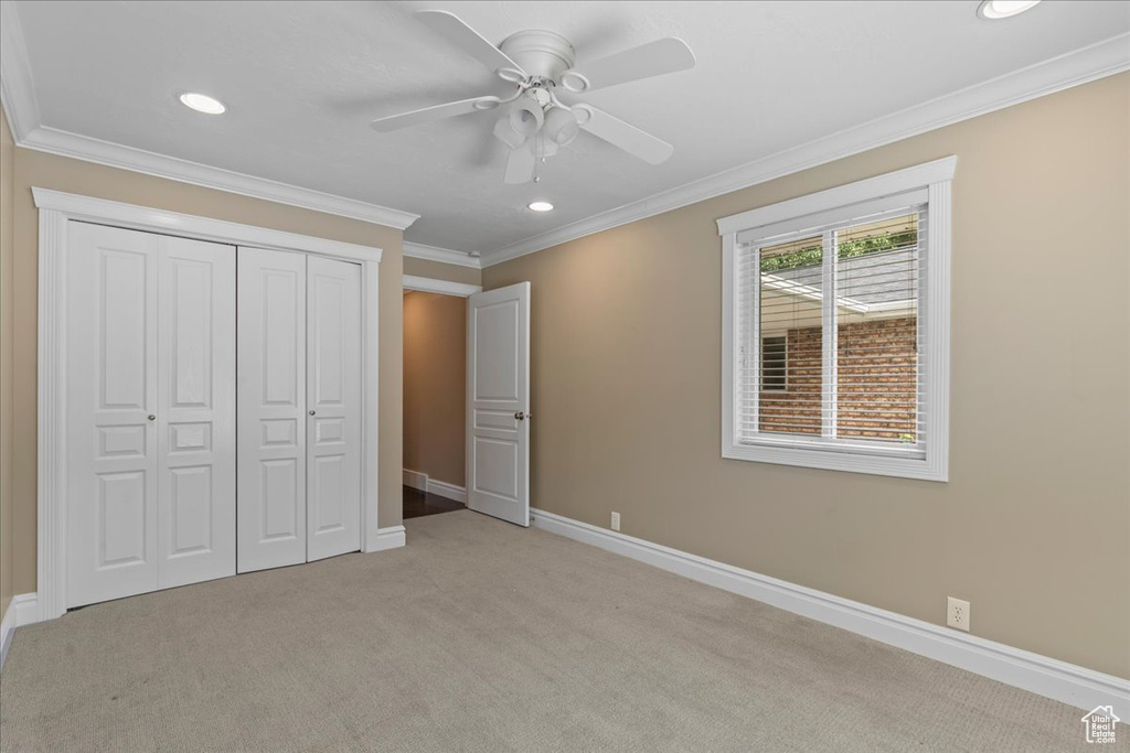 Unfurnished bedroom with recessed lighting, light colored carpet, a closet, ornamental molding, and ceiling fan
