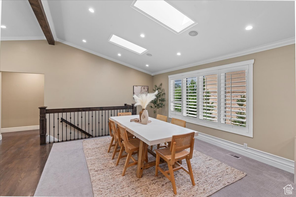 Dining area with a skylight, crown molding, recessed lighting, and wood finished floors
