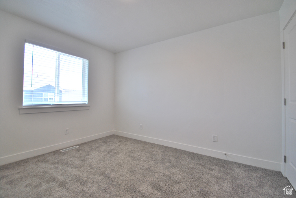 Empty room featuring carpet floors and baseboards