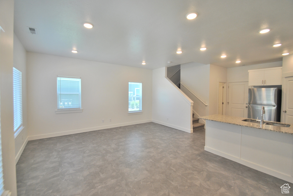 Unfurnished living room featuring recessed lighting, stairway, and tile patterned floors