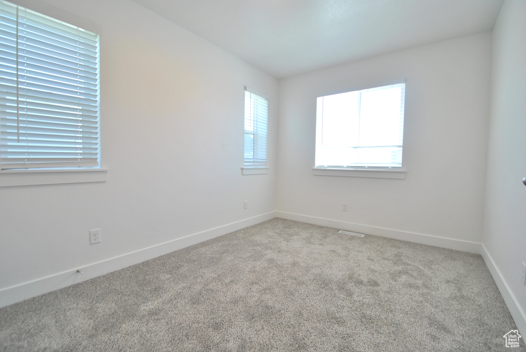 Carpeted empty room with baseboards