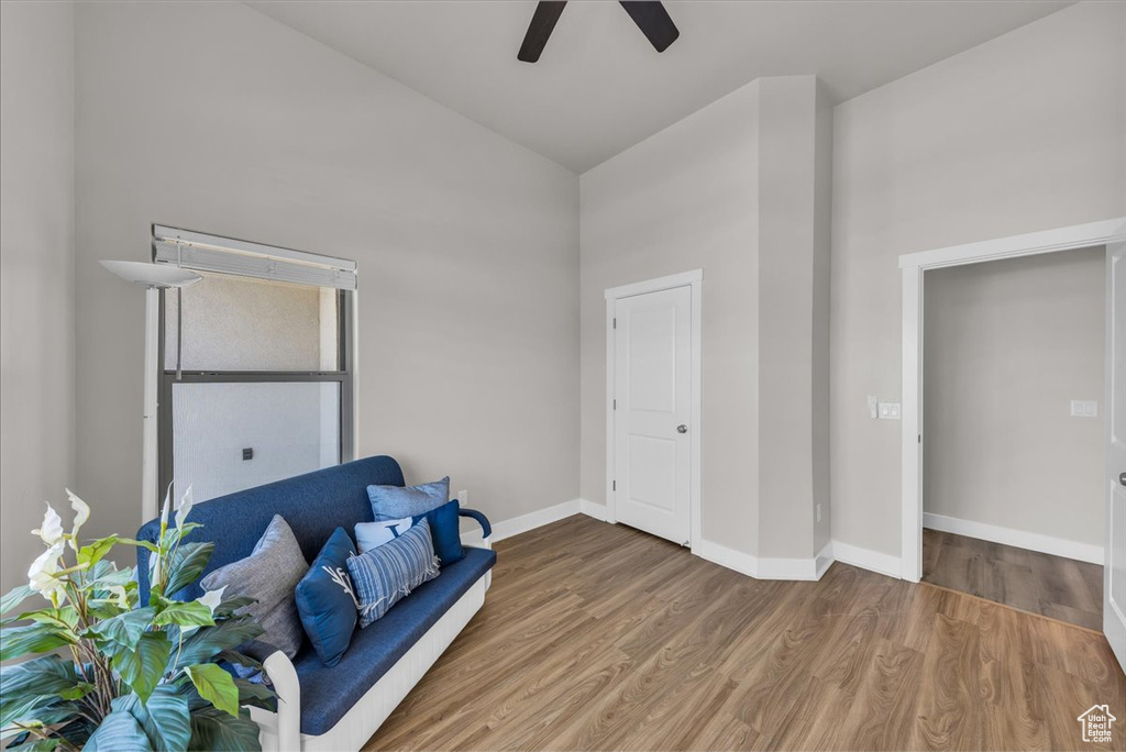 Living area featuring ceiling fan, wood finished floors, and high vaulted ceiling