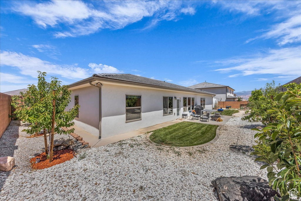 Rear view of property featuring a fenced backyard, a patio area, and stucco siding