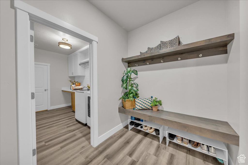Mudroom with light wood-style floors and independent washer and dryer
