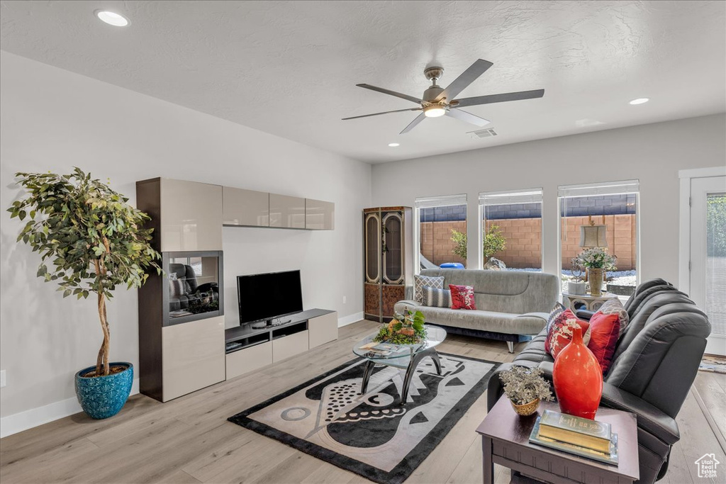 Living room featuring a ceiling fan, light wood-type flooring, and recessed lighting
