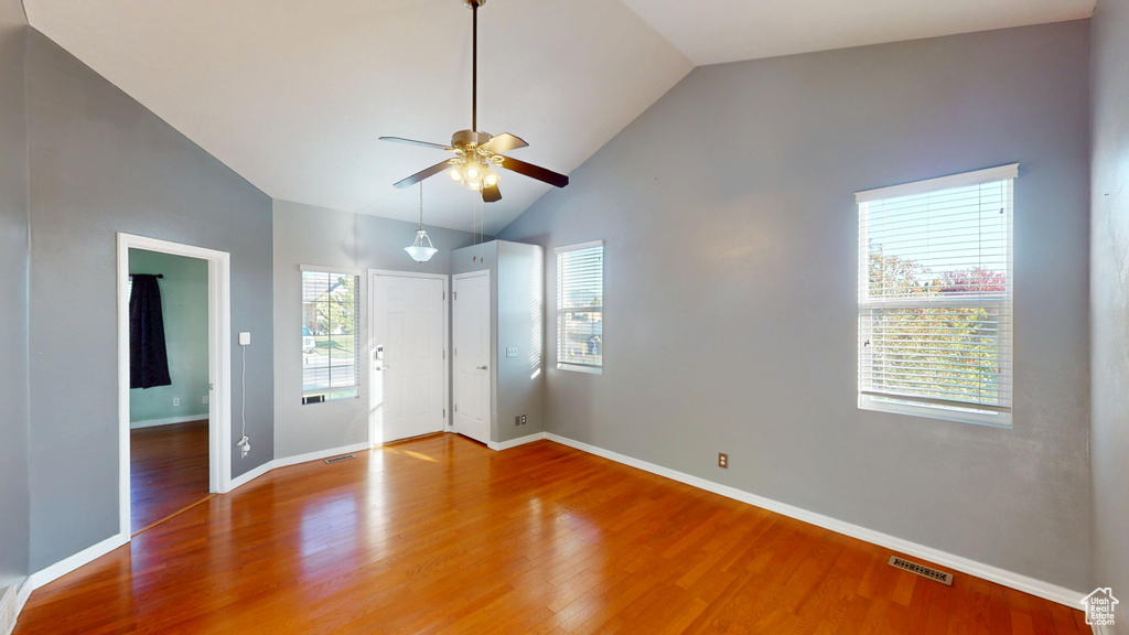 Unfurnished bedroom with wood finished floors and high vaulted ceiling
