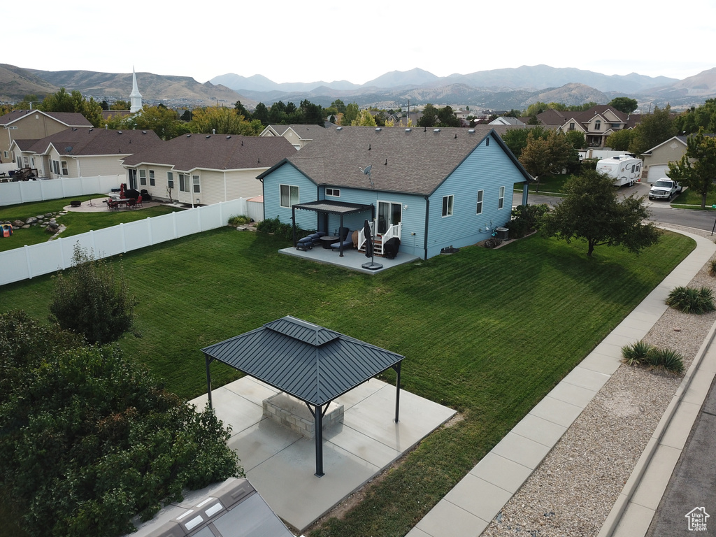Back of property with a gazebo, a residential view, and a mountain view