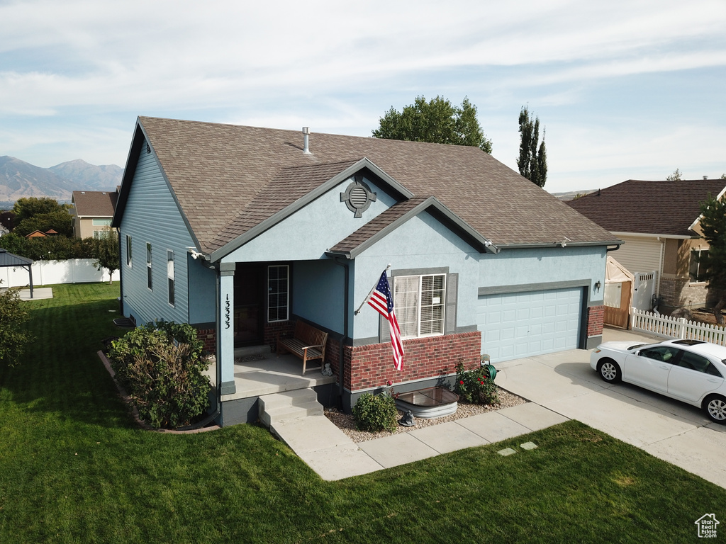 Single story home with a shingled roof, concrete driveway, a garage, brick siding, and stucco siding