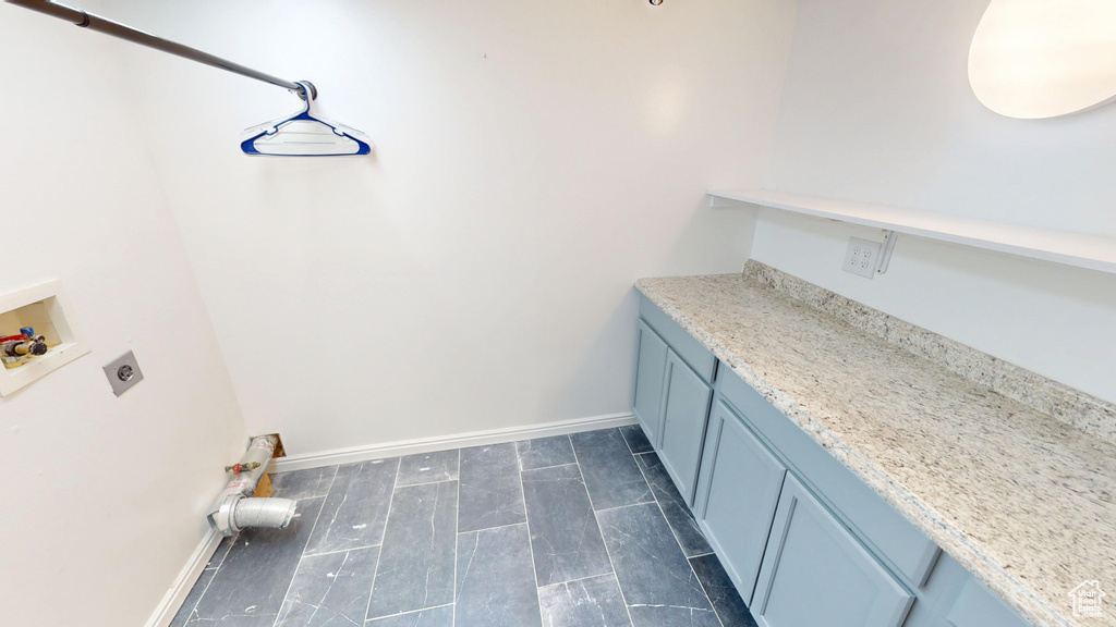 Washroom with electric dryer hookup, washer hookup, and cabinet space