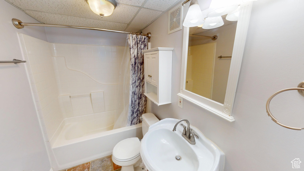 Bathroom with shower / tub combo and a drop ceiling