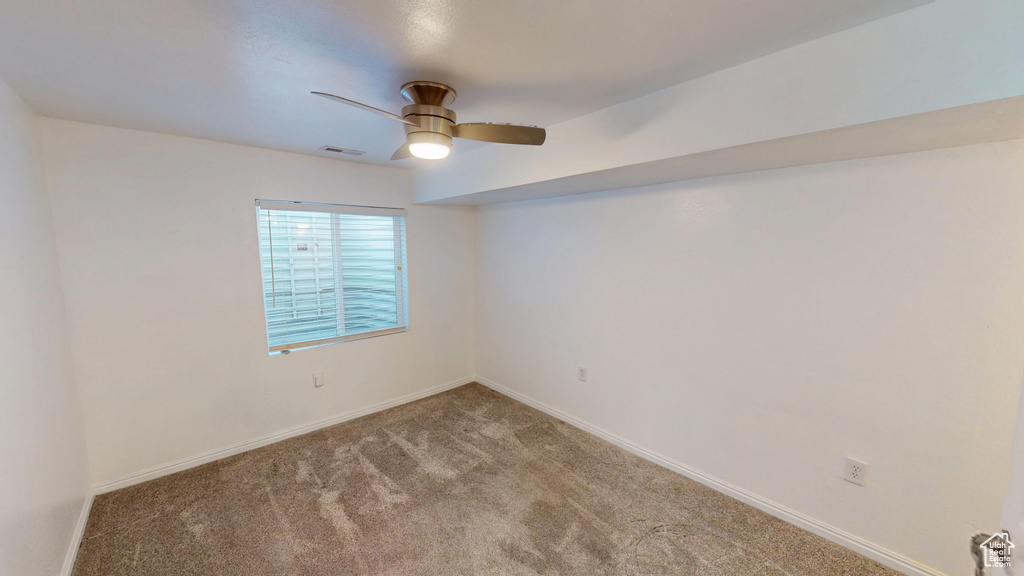 Empty room with ceiling fan and carpet