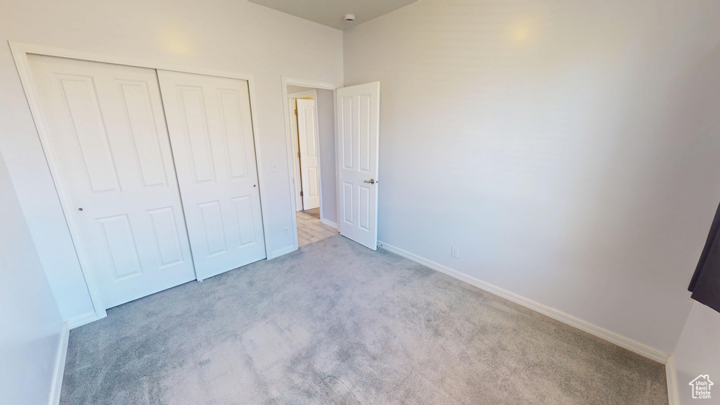Unfurnished bedroom featuring carpet floors and a closet