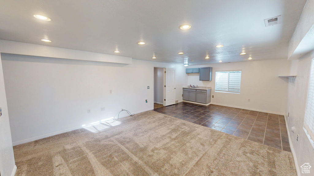 Basement featuring dark tile patterned floors, recessed lighting, and dark carpet