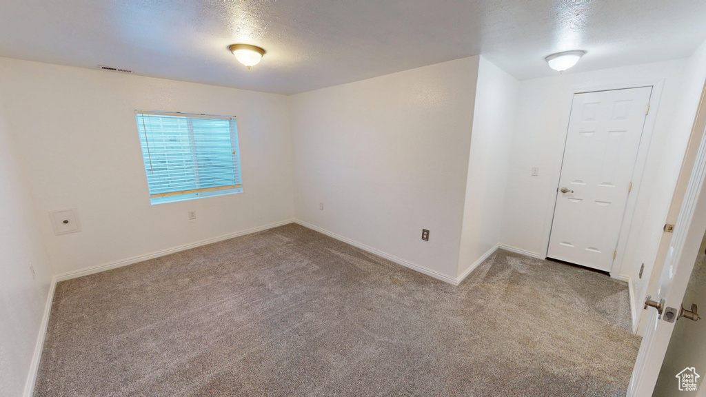 Empty room featuring carpet and baseboards