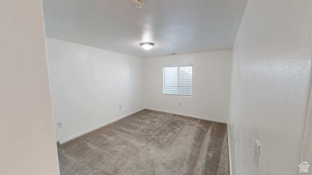 Unfurnished room featuring carpet flooring and a smoke detector