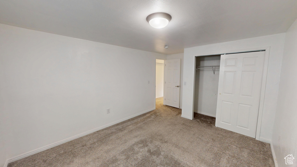 Unfurnished bedroom with carpet and a closet
