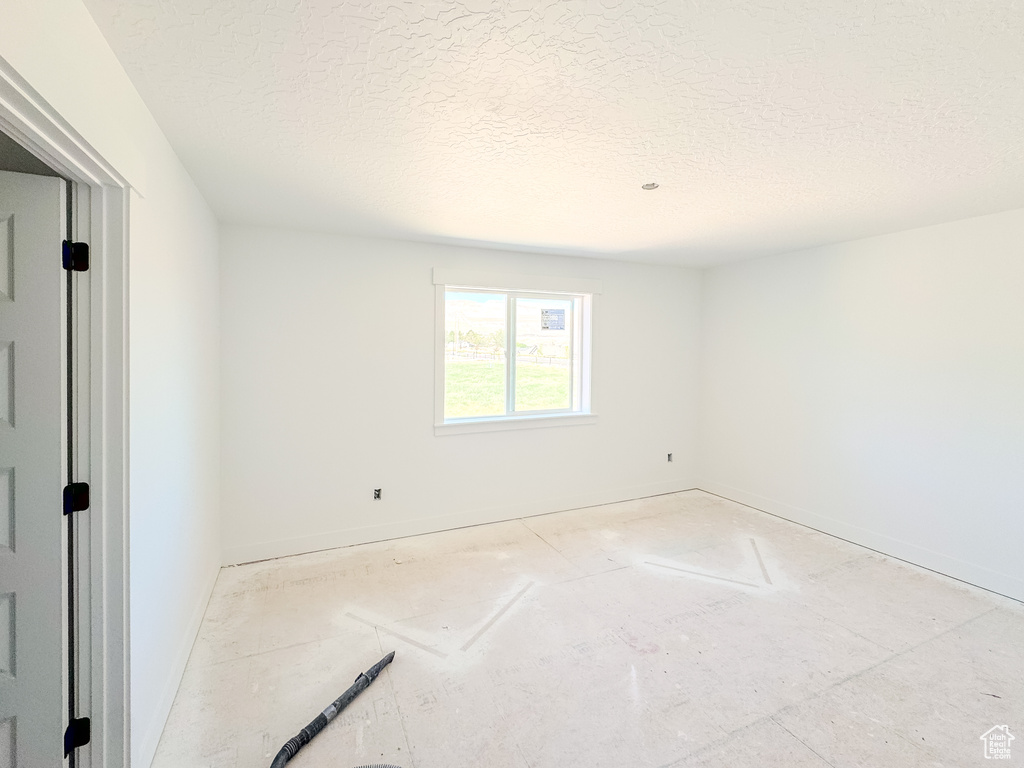 Unfurnished room with a textured ceiling