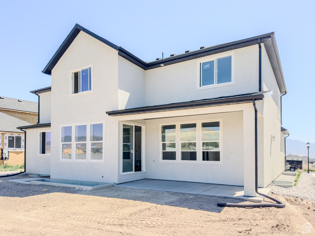 Back of property with a patio and stucco siding