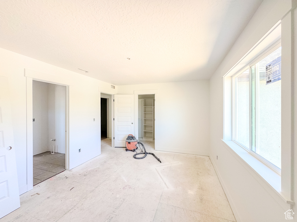 Unfurnished bedroom with baseboards and a textured ceiling