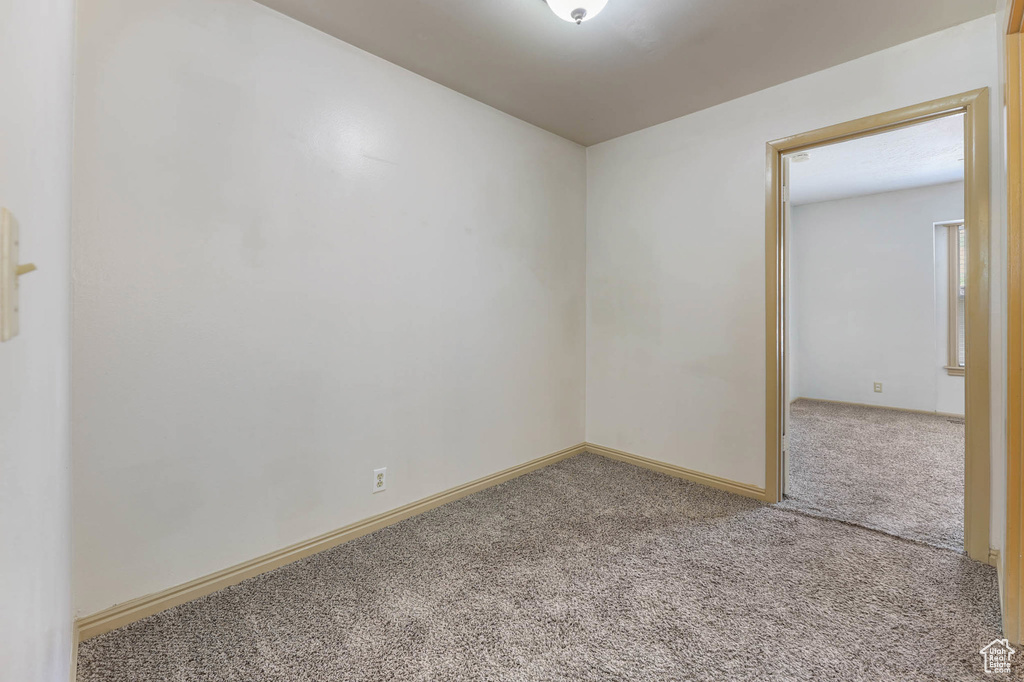 Carpeted empty room featuring baseboards