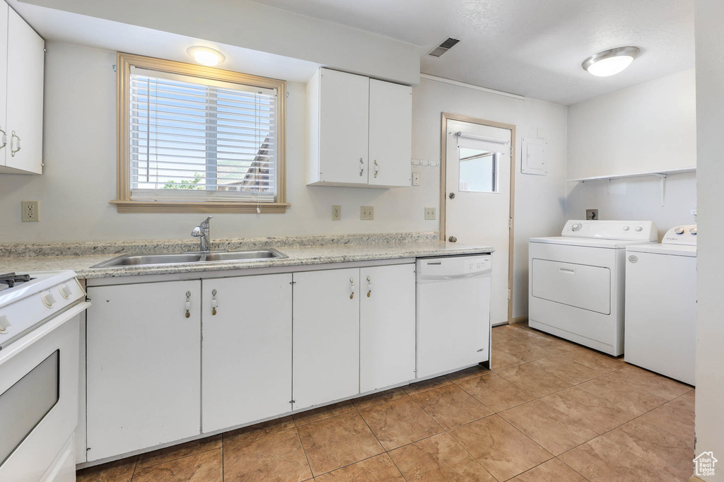Laundry area featuring washing machine and clothes dryer, plenty of natural light, and light tile patterned floors