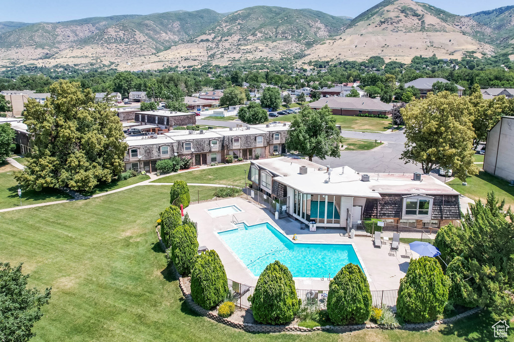 Community pool featuring a patio, a mountain view, and a lawn