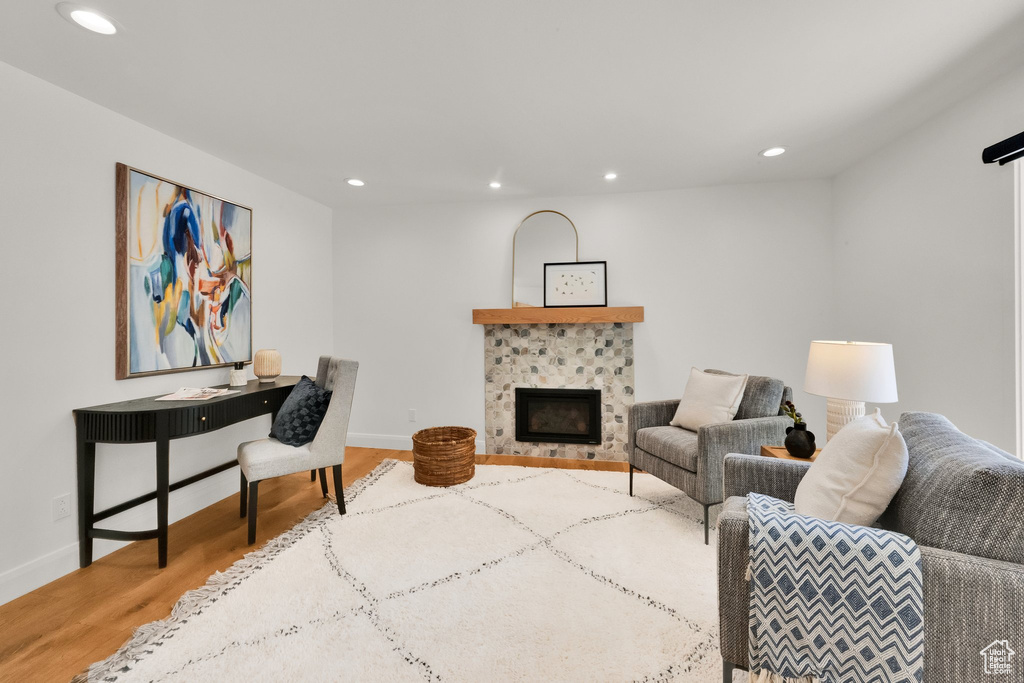 Living room with recessed lighting, wood finished floors, and a fireplace