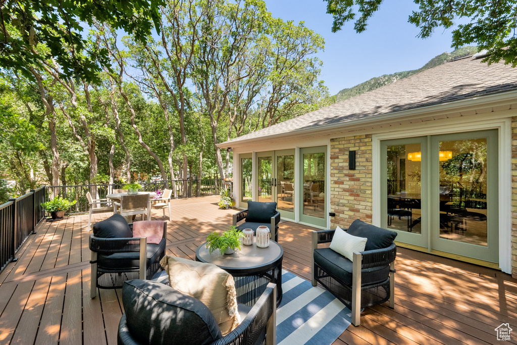 Wooden terrace with outdoor dining space, an outdoor living space, and french doors