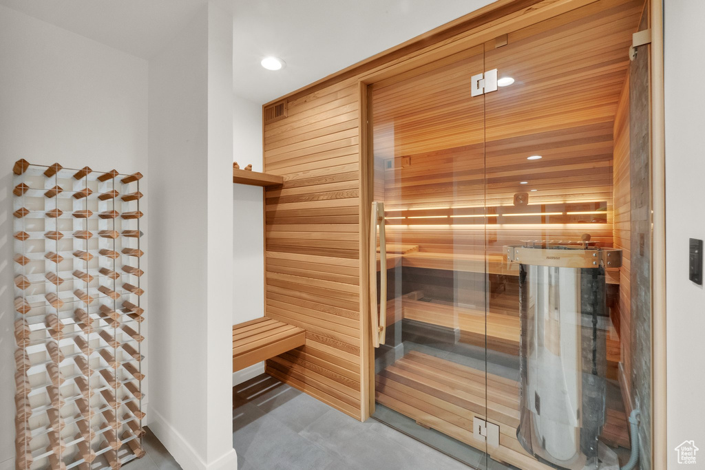Relaxing sauna with recessed lighting and concrete flooring
