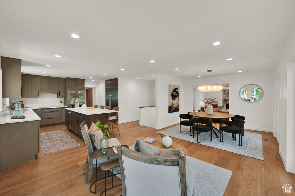 Living room featuring recessed lighting, light wood-style flooring, and a chandelier