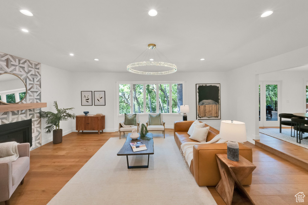 Living area with recessed lighting, wood finished floors, and a stone fireplace
